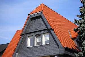 Tipp zum Bau zeigt die Verkleidung eines Hauses mit Ziegeln und Schiefer: Auch bei der Dachgaube eine interessante Optik.