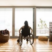 Junge behinderte Frau im Rollstuhl zu Hause, Rückblick.